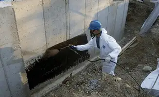 Professional waterproofing the exterior walls of the basement in Bloomington, IN