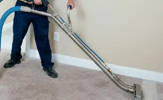 Professional operating a liquid removal machine on a carpeted floor in Bloomington, IN